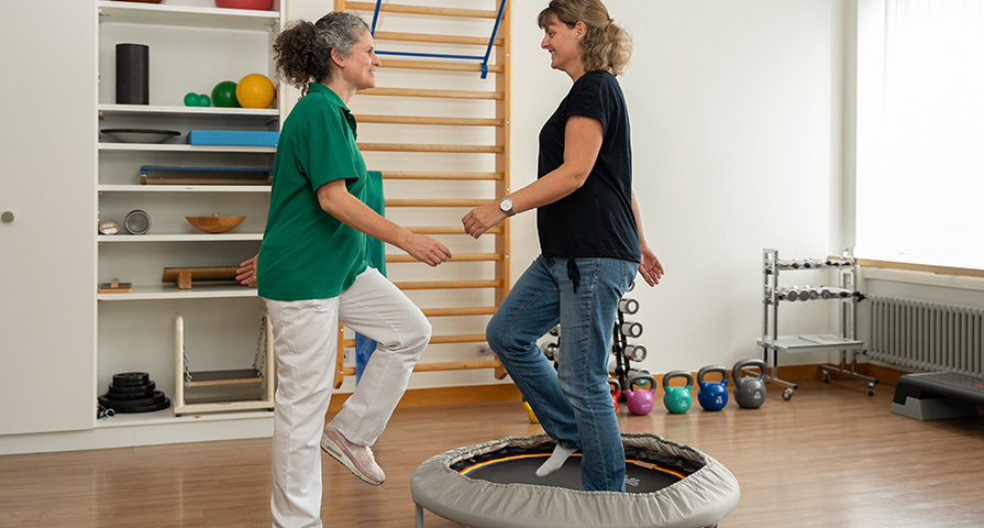 Eine Beckenboden-Physiotherapeutinnen zeigt einer Patientin Übungen für ein gezieltes Muskeltraining im Rahmen der Beckenboden-Rehabilitation.